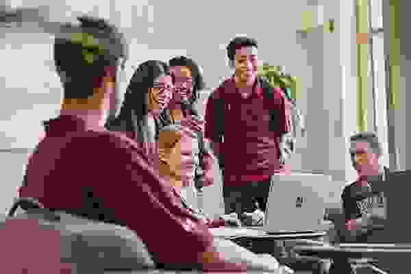 students gathered around a laptop